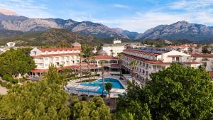 a resort with a pool and mountains in the background at Fun Sun Smart Lurea Beach in Kemer
