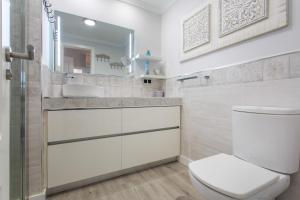 a bathroom with a toilet and a sink and a mirror at Veras Home in La Tejita +21 photos