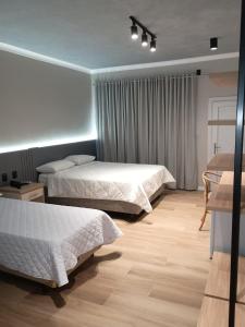 a hotel room with two beds and a table at Hotel Premier in Santa Rita