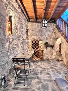 a patio with a table and chairs in a stone wall at Casa da Maria Reguila in Porto