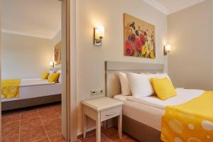 a bedroom with a bed with yellow and white pillows at Fun Sun Smart Lurea Beach in Kemer +37 photos