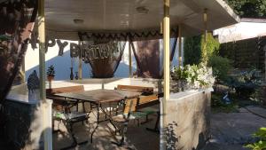 a patio with a wooden table and chairs under an umbrella at Dacha Pool and Grill in Karavan