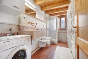 a bathroom with a washing machine and a toilet at Casa Sole in Ceniga