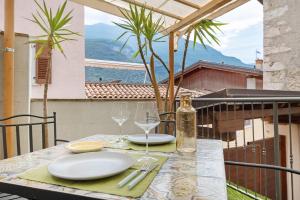 a table with plates and wine glasses on a balcony at Casa Sole in Ceniga