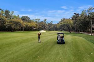 a man is playing golf with a golf cart at GA181: 181 Glen Abbey in Kiawah Island