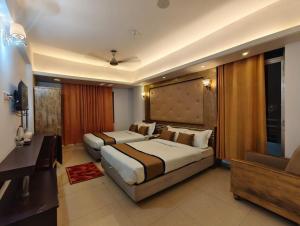 a hotel room with two beds and a desk at The White Beach Resort in Cox's Bazar