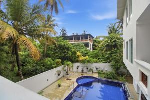 a balcony with a swimming pool and a building at Mihira Gedara Apartments in Unawatuna