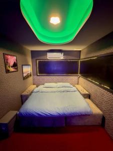 a bedroom with a large bed with a green ceiling at Holy Hostel Sukhumvit 22 in Bangkok