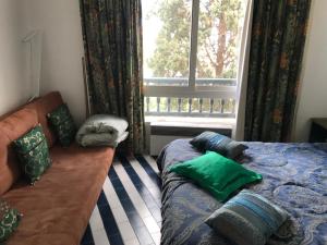 a bedroom with a bed and a window and a couch at Vue superbe in Port El Kantaoui