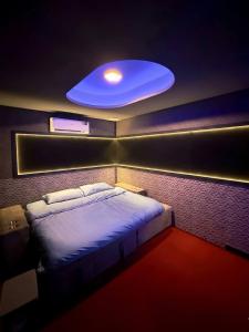 a bedroom with a large bed with a blue light at Holy Hostel Sukhumvit 22 in Bangkok
