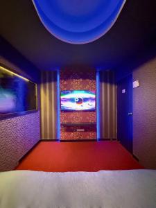 a room with a bed and a television in a room at Holy Hostel Sukhumvit 22 in Bangkok