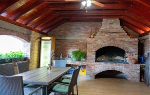 a brick fireplace with a table and chairs in front of it at Kuća za odmor Serdar in Slavonski Brod