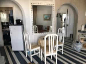 a dining room with a table and two chairs and a mirror at Vue superbe in Port El Kantaoui