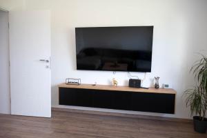 a flat screen tv hanging on a white wall at Kuća za odmor Serdar in Slavonski Brod