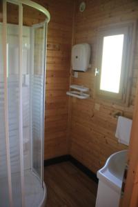 a bathroom with a shower and a sink and a window at Camping de Saint Just - Onlycamp in Arcomie