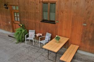 ein Holztisch und Stühle neben einem Gebäude in der Unterkunft Bocksleitnerhof in Wackersberg + 58 Fotos