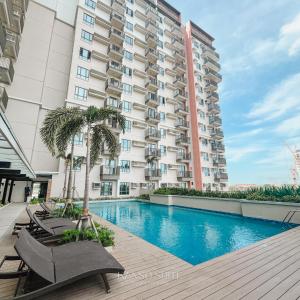 a hotel with a swimming pool and a building at Studio with Free Pool Access & Night Swimming in Capitol Town in San Fernando