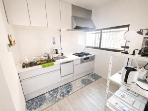 a white kitchen with a sink and a stove at New Entire Family House 1 Min to Metro Umeda Direct in Osaka