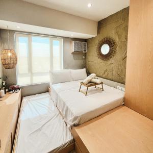 a room with two beds and a table on it at Studio with Free Pool Access & Night Swimming in Capitol Town in San Fernando +18 photos