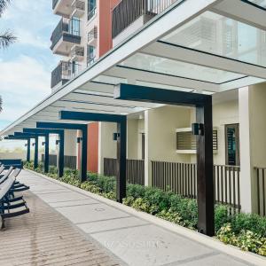 a building with a walkway with benches and a building at Studio with Free Pool Access & Night Swimming in Capitol Town in San Fernando