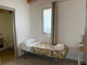 a small bedroom with a bed and a window at Sole e Luna in Lonato +13 photos