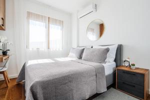 a white bedroom with a bed and a mirror at Anna Luxury BELLA VISTA in Baošići