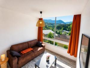 a living room with a couch and a large window at Studio Les Petits Marcheurs in Saint-Claude