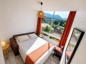 a bedroom with a bed and a large window at Studio Les Petits Marcheurs in Saint-Claude