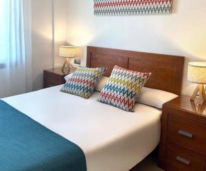 a bedroom with a bed with two pillows on it at Ona Jardines Paraisol in Salou +10 photos
