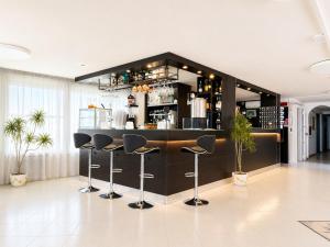 a bar with black bar stools in a room at Hotel TYC in Rimini