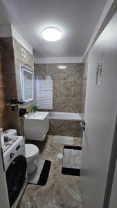 a bathroom with a toilet and a tub and a sink at Divine Luxury Rasnov in Râşnov +30 photos