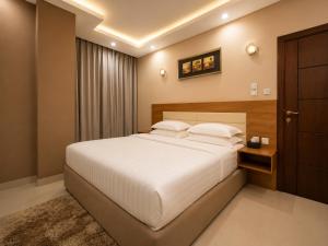 a bedroom with a large white bed and a window at Elsafa Hotel in Salalah