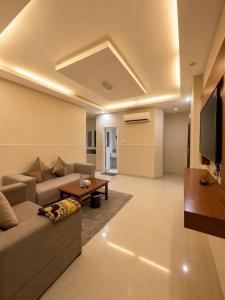 a living room with a couch and a tv at Elsafa Hotel in Salalah