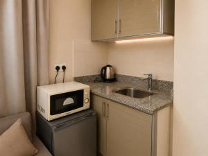 a small kitchen with a sink and a microwave at Elsafa Hotel in Salalah