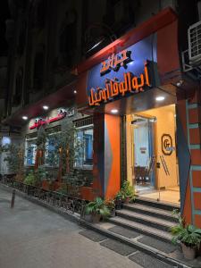 a restaurant with a sign on the side of a building at Hotel G in Sūhāj