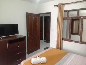 a bedroom with a bed and a flat screen tv at Hostal Center A in Santa Cruz de la Sierra