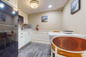 a kitchen with white cabinets and a table and chairs at Nurse-Ready Studio Retreat! 2 Mi to Dtwn Holyoke in Holyoke
