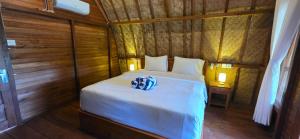 a bedroom with a bed with two towels on it at Bilva Garden Penida in Polilit +7 photos