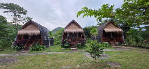 a group of three huts with grass roofs at Bilva Garden Penida in Polilit