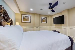 a bedroom with a white bed and a flat screen tv at Nurse-Ready Studio Retreat! 2 Mi to Dtwn Holyoke in Holyoke