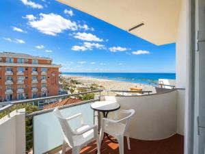 a balcony with a table and chairs and a view of the beach at Hotel TYC in Rimini