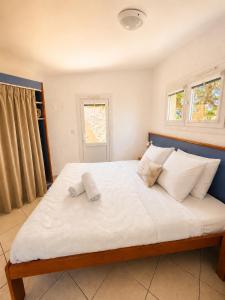 a bedroom with a large white bed with two towels on it at Charmant studio avec terrasse in Fréjus