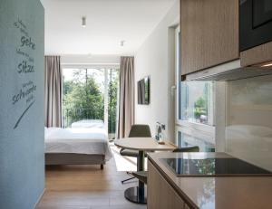 a hotel room with a bed and a kitchen with a table at stay flex Hotel & Apartment in Hertenstein