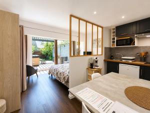 a kitchen and a bedroom with a bed and a table at Aux Matins du Bonheur in Surzur