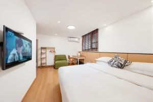 a bedroom with a bed and a flat screen tv at 闲山民宿 CosyValley Inn in Hangzhou
