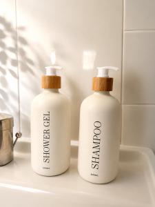 two bottles of detergent sitting on a bathroom sink at Charmant studio avec terrasse in Fréjus