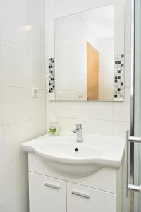a white bathroom with a sink and a mirror at Cottage Sunshine in Jajce