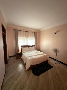 a bedroom with a large bed and a window at Express Living & Wellness in Jinja