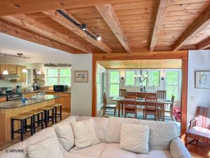 a living room with a couch and a kitchen at Shady Lane Retreat in Waitsfield