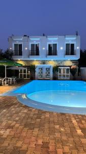 a large swimming pool in front of a house at Hotel Adriatik Orikum in Orikum